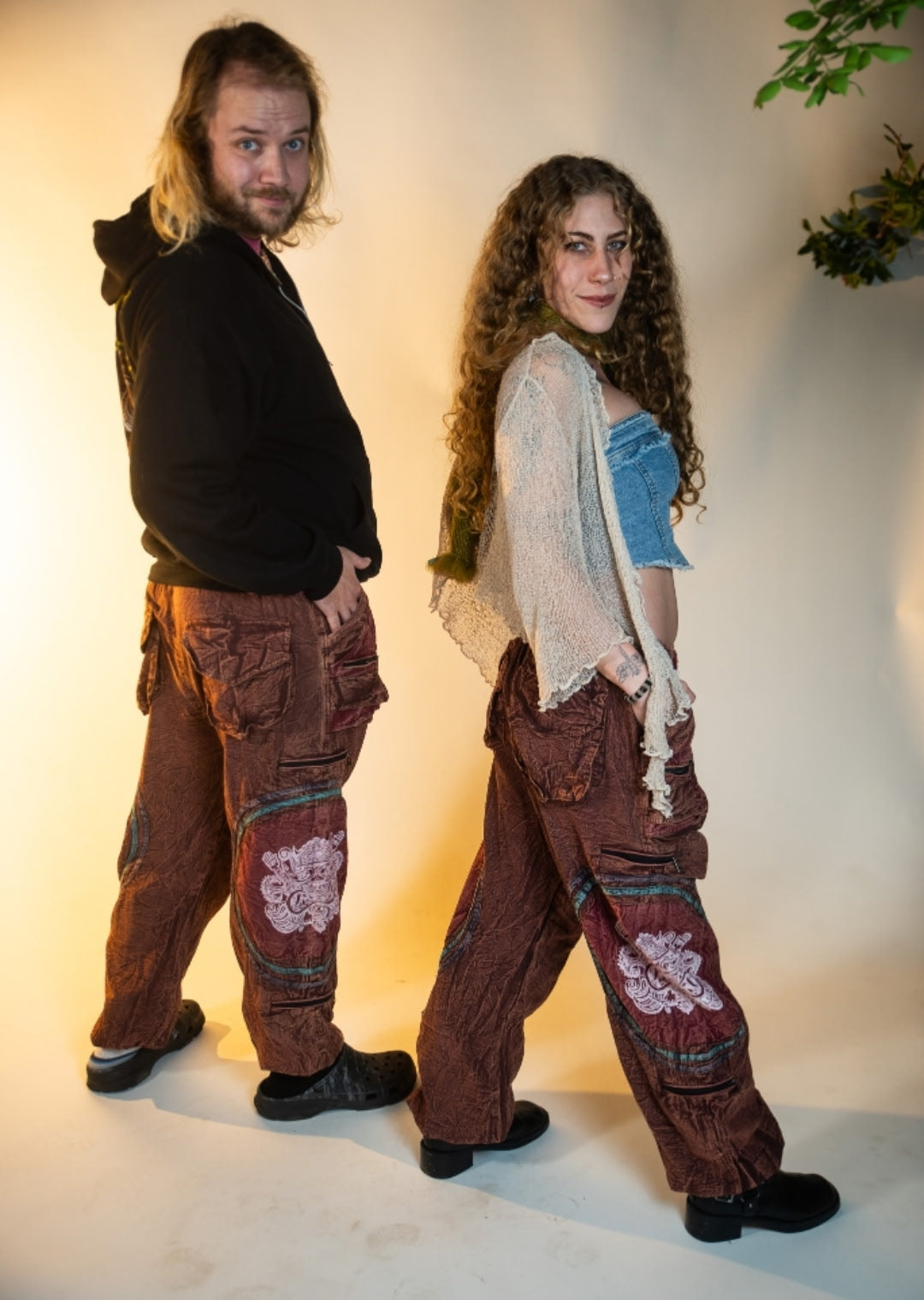 Two models wearing handmade burgundy Chris Dyer Dyer-Jawnz parachute pants, showing the relaxed unisex fit and patchwork details.