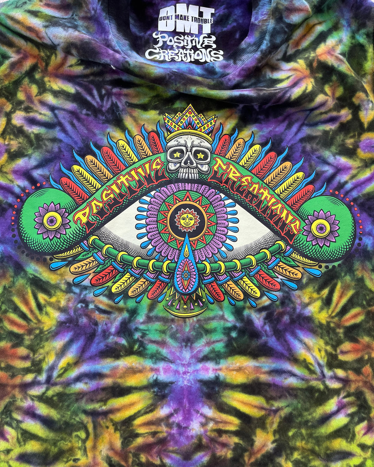 Close-up of Chris Dyer Positive Eye artwork on Cosmic purple, yellow and green handmade tie-dye long-sleeve shirt