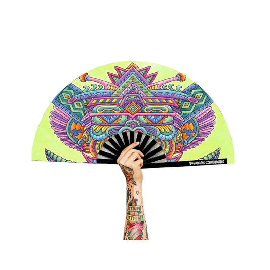 A tattooed hand holds the Festival Folding Fan – Light Worker & Taita Inti, displaying psychedelic, geometric, cat-inspired patterns in vivid colors against a plain white background.